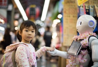 A photo of a child shaking hand with a robot