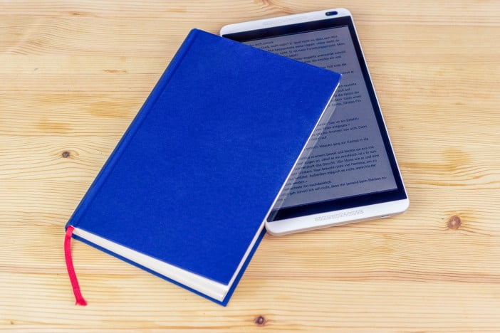 5 Uses For Old Android And Ios Devices 1 A Photo Of The Tablet With An Ebook Opened, Placed Inside A Blue Book