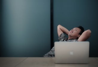 A photo of a happy person with his Apple MacBook