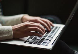a person typing on laptop