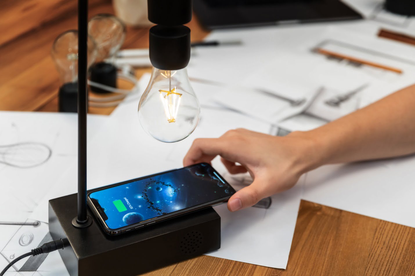 Latest Trend: Wireless Electricity Meets Levitation In This New Gadget 3 A Woman Placing Her Iphone On The Wireless Charging Pad Of Gravita
