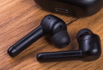 A pair of wireless headphones on a wooden table