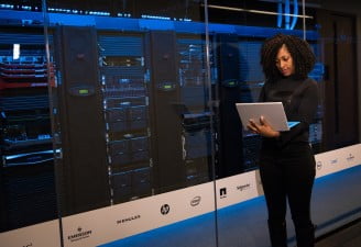 A girl using laptop near servers