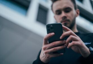 A photo of a man using his iPhone