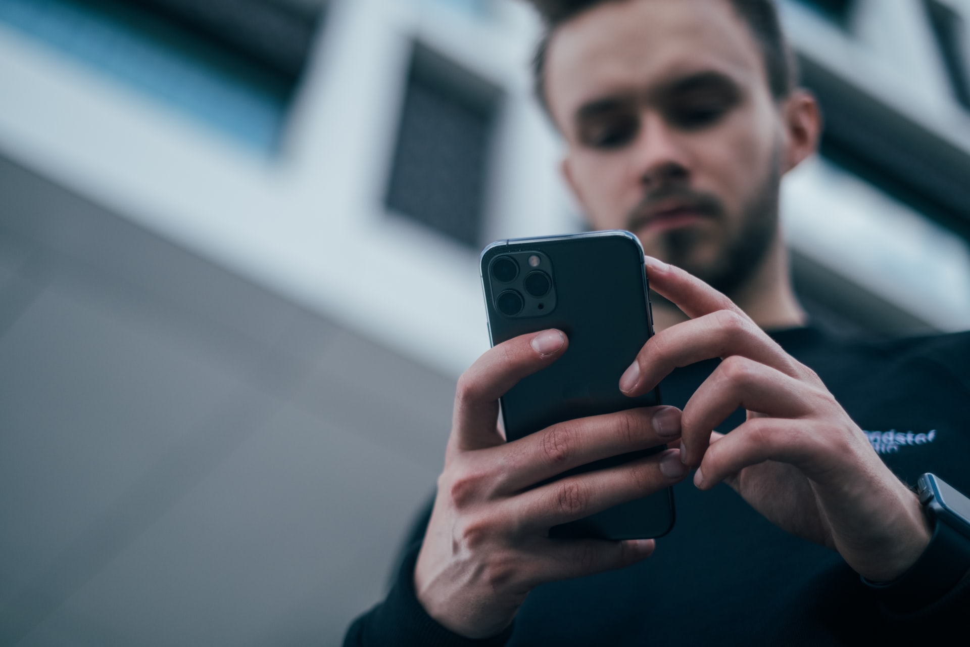 A photo of a man using his iPhone